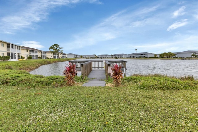 view of dock with a water view and a lawn