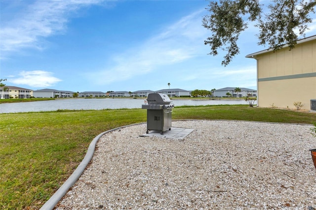 view of yard featuring a residential view, a water view, and central air condition unit