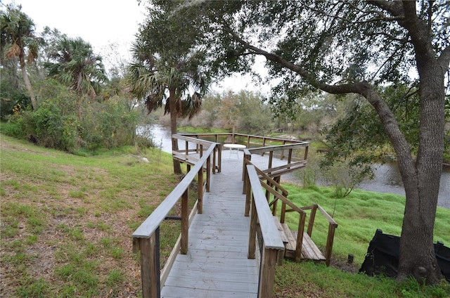 view of dock featuring a water view and a lawn