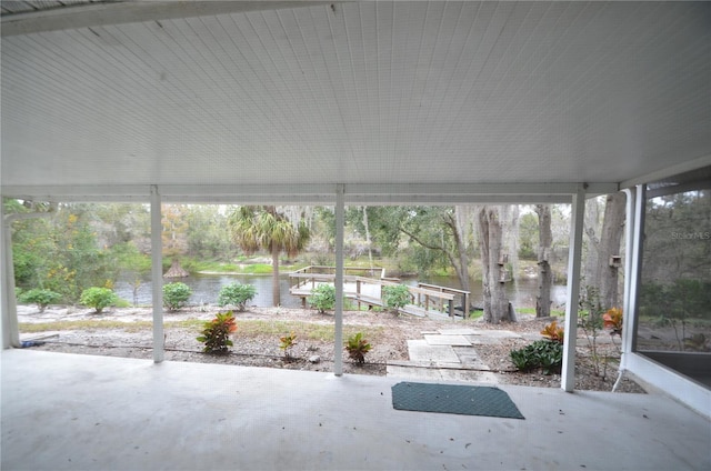 unfurnished sunroom featuring a water view