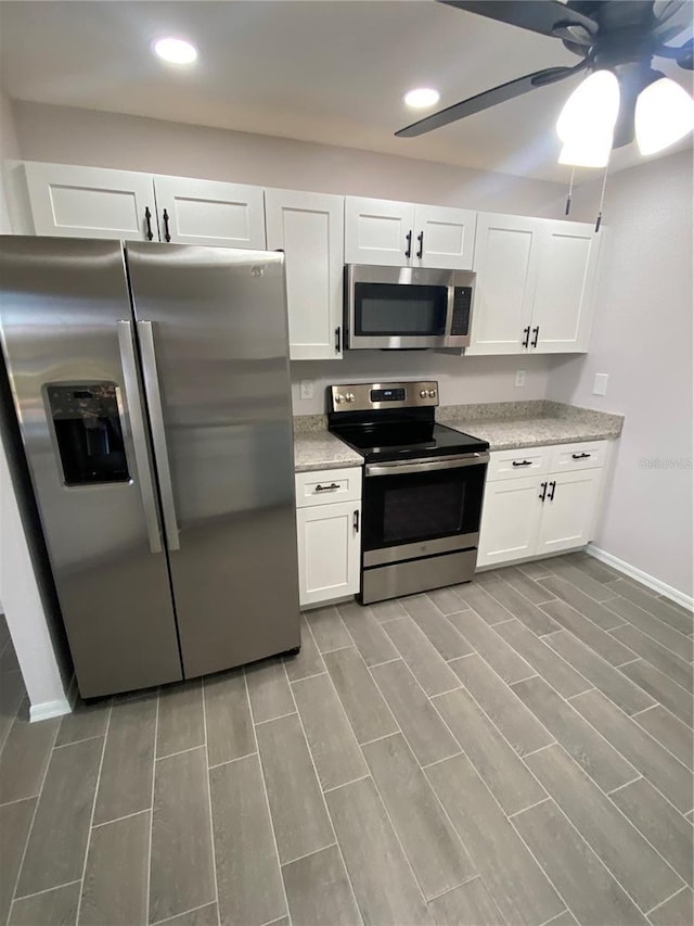 kitchen featuring a ceiling fan, appliances with stainless steel finishes, light stone counters, white cabinetry, and recessed lighting