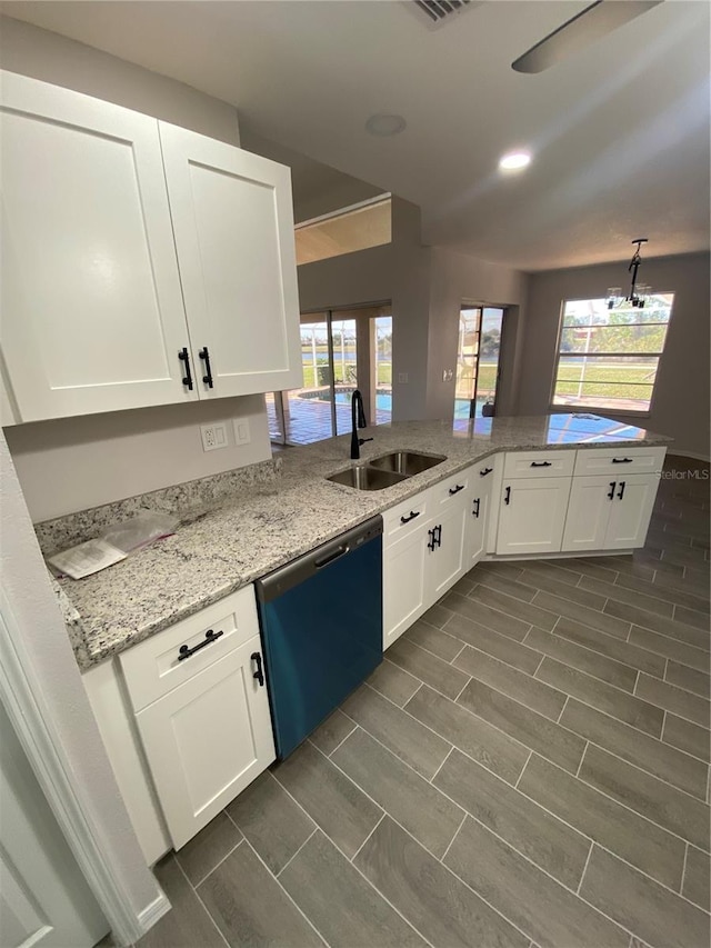 kitchen featuring visible vents, white cabinets, a sink, light stone countertops, and dishwashing machine