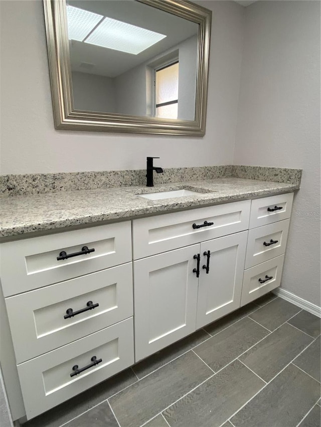 bathroom featuring baseboards and vanity