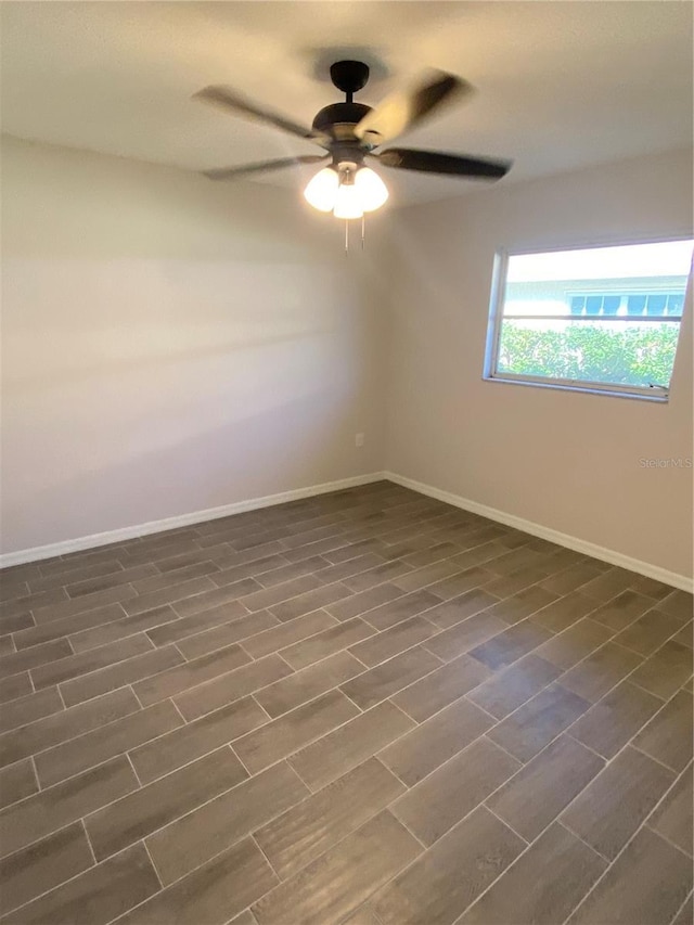 spare room featuring dark wood-style floors, baseboards, and a ceiling fan