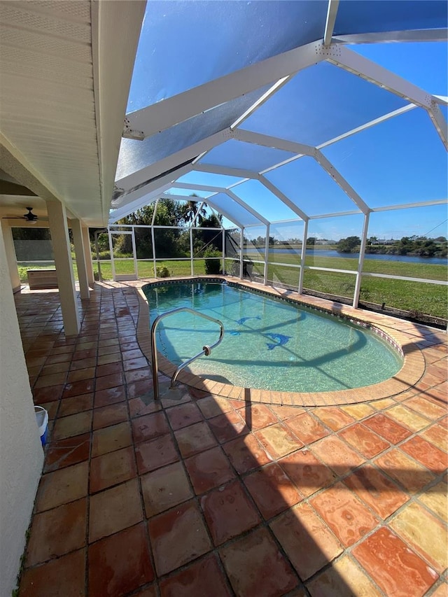 outdoor pool featuring ceiling fan, a lawn, a patio area, and a lanai