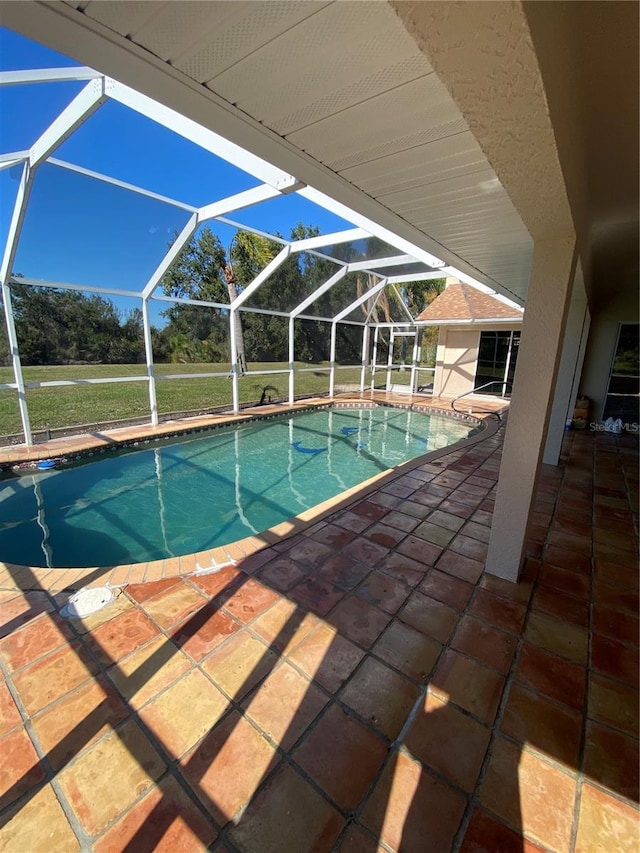 pool featuring glass enclosure and a patio