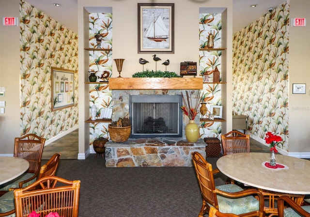 carpeted dining room with a stone fireplace