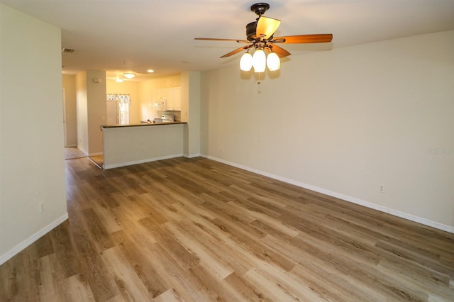 unfurnished living room with ceiling fan and hardwood / wood-style flooring