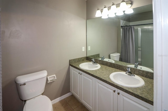 bathroom with tile patterned floors, vanity, toilet, and walk in shower