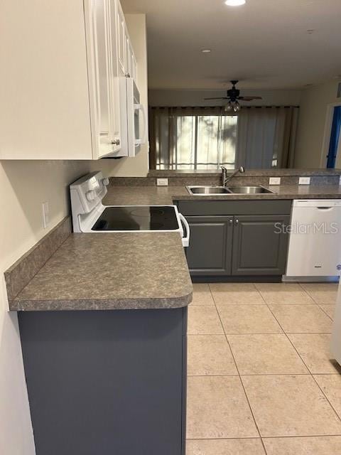 kitchen featuring sink, kitchen peninsula, white appliances, gray cabinets, and light tile patterned floors