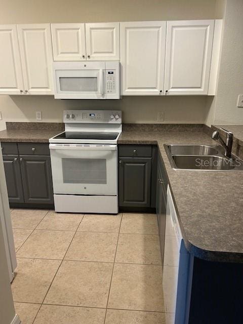 kitchen featuring white cabinets, white appliances, sink, and light tile patterned floors