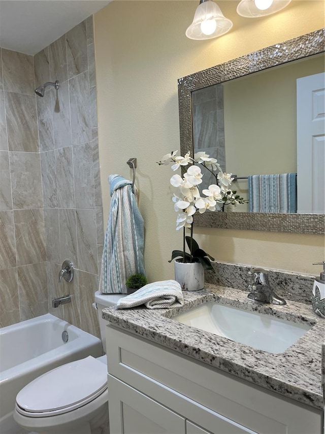 full bathroom with vanity, toilet, and tiled shower / bath combo