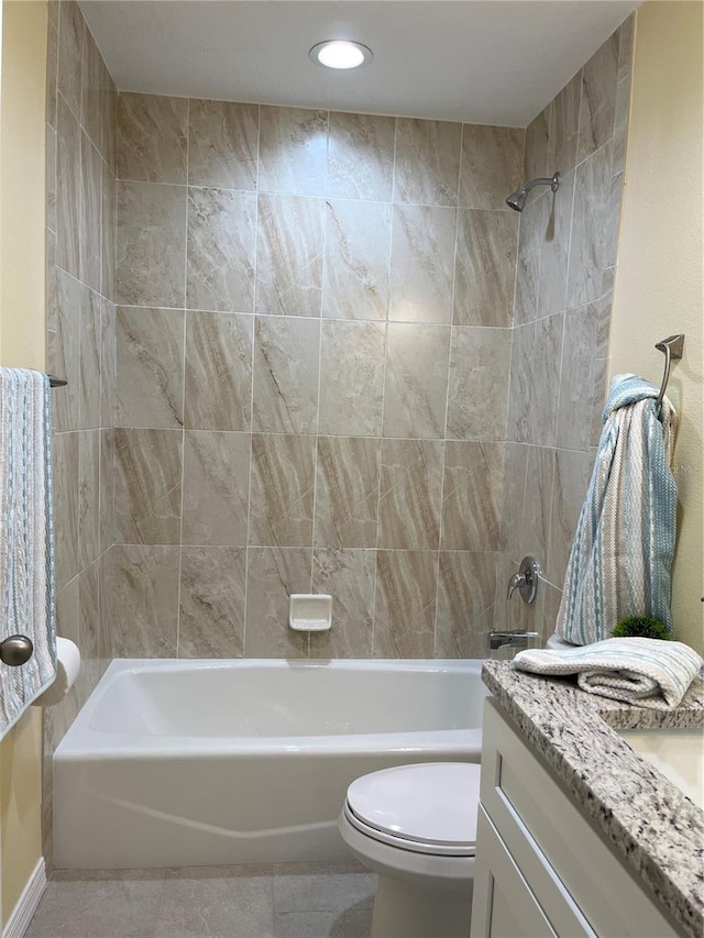 full bathroom featuring vanity, tiled shower / bath, tile patterned floors, and toilet