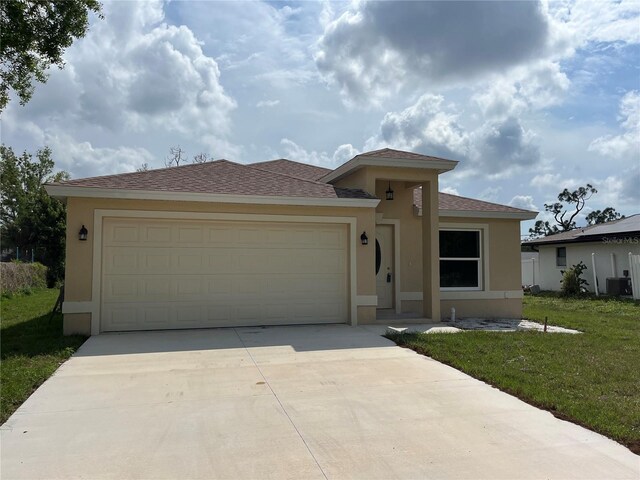 view of front facade with a garage, central AC unit, and a front lawn