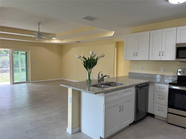 kitchen with white cabinetry, stainless steel appliances, kitchen peninsula, and a raised ceiling