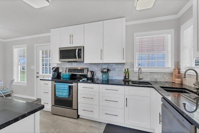 kitchen with white cabinets, stainless steel appliances, sink, and crown molding