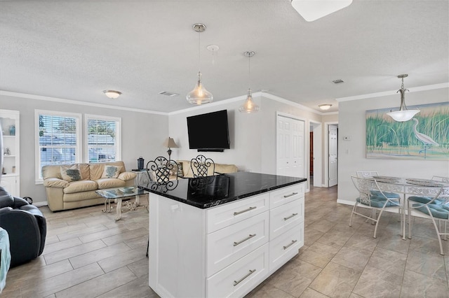 kitchen with white cabinets, pendant lighting, crown molding, and a center island