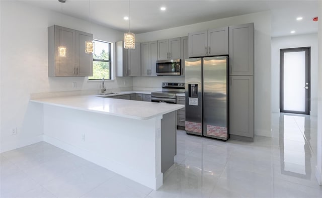 kitchen with light tile patterned floors, stainless steel appliances, hanging light fixtures, and sink