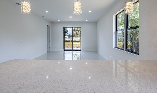 spare room with a notable chandelier and a wealth of natural light