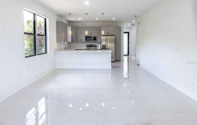 kitchen with stainless steel appliances, gray cabinetry, sink, decorative light fixtures, and light tile patterned floors