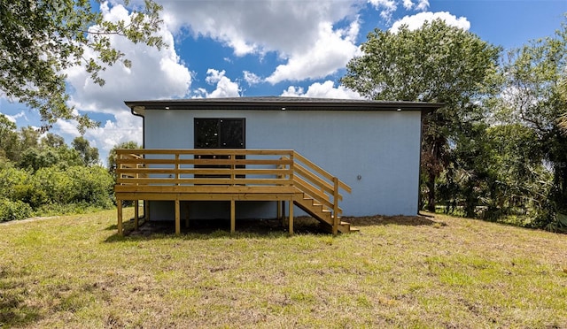 back of house featuring a wooden deck and a yard