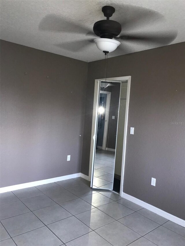 4127 Gardner Dr, Port Charlotte, FL 33952 - unfurnished room featuring a textured ceiling, ceiling fan, light tile patterned flooring, and baseboards