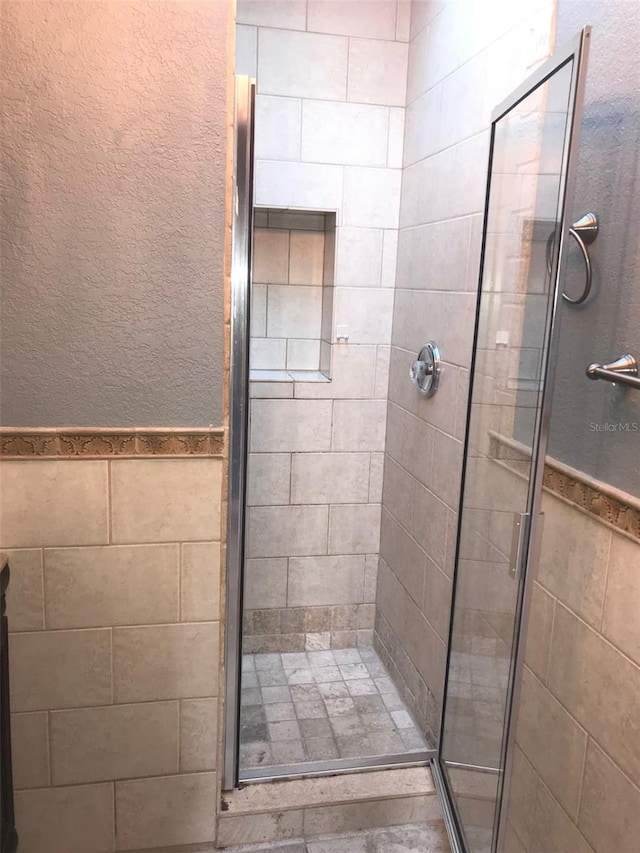 4127 Gardner Dr, Port Charlotte, FL 33952 - full bathroom with a stall shower, tile walls, and wainscoting