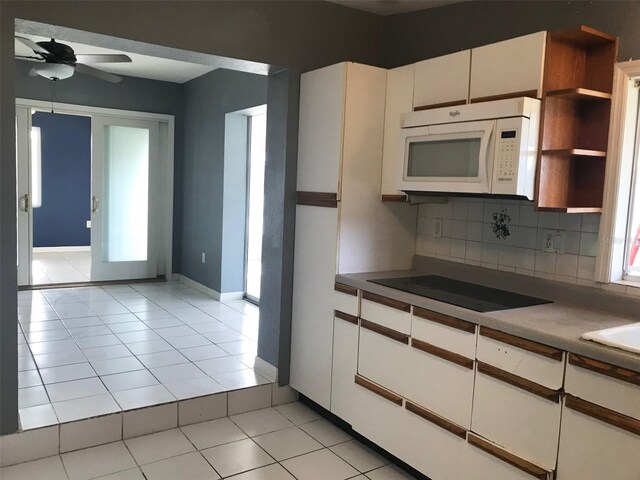 4127 Gardner Dr, Port Charlotte, FL 33952 - kitchen featuring tasteful backsplash, white microwave, black electric stovetop, white cabinetry, and open shelves