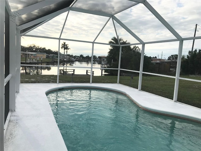 4127 Gardner Dr, Port Charlotte, FL 33952 - outdoor pool with glass enclosure, a water view, a lawn, and a patio