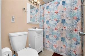 bathroom with vanity, a shower with curtain, and toilet