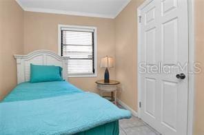 bedroom with crown molding and light tile patterned floors