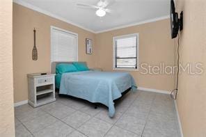 tiled bedroom featuring crown molding and ceiling fan