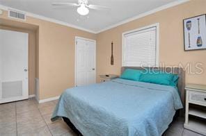 tiled bedroom featuring ceiling fan and ornamental molding