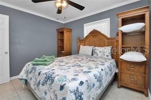 tiled bedroom with ceiling fan and ornamental molding