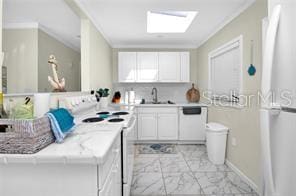 kitchen featuring sink, a skylight, kitchen peninsula, electric stove, and white cabinets