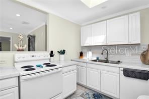 kitchen with white cabinetry, sink, white appliances, and decorative backsplash