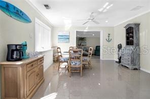 dining area with crown molding and ceiling fan