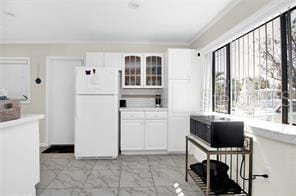 kitchen with white refrigerator and white cabinetry