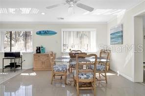 tiled dining space with crown molding and ceiling fan