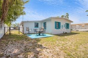 rear view of house featuring a yard and a patio