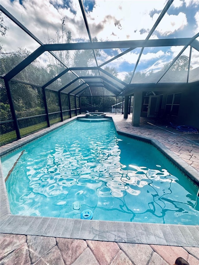 view of pool featuring glass enclosure and a patio