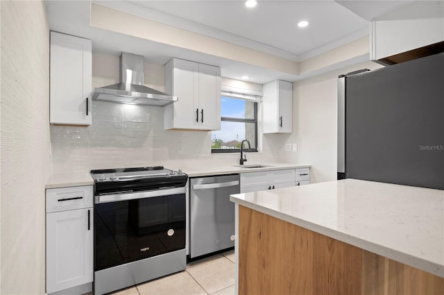 kitchen with light tile patterned flooring, sink, white cabinetry, wall chimney exhaust hood, and stainless steel appliances