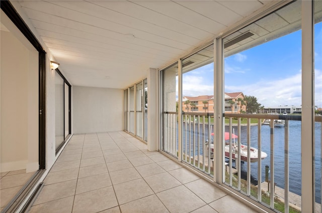 unfurnished sunroom featuring a water view