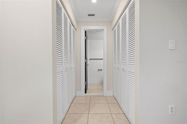 hall with light tile patterned flooring and ornamental molding