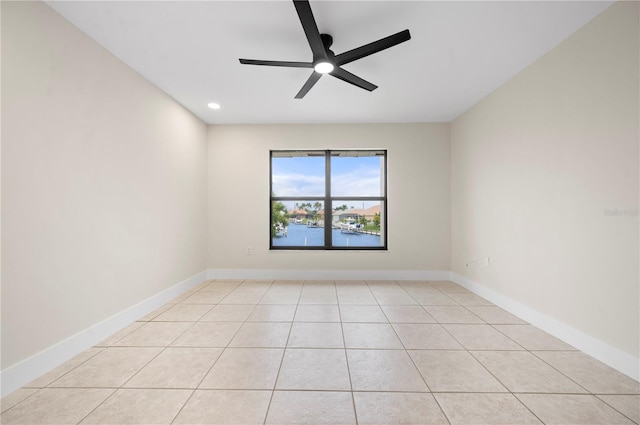 spare room with ceiling fan and light tile patterned floors