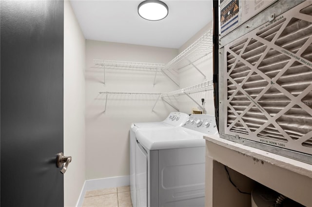 laundry area with light tile patterned flooring and washer and dryer