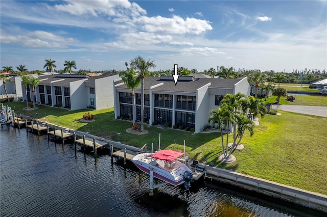 rear view of house featuring a water view, a yard, and a sunroom