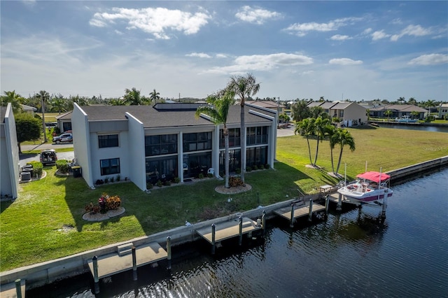 rear view of house with a water view and a yard