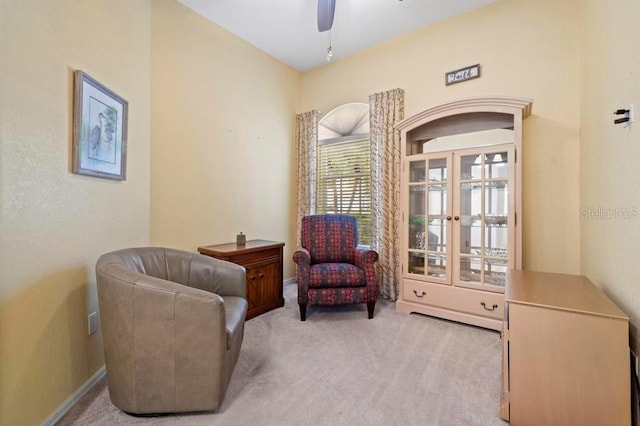 sitting room with ceiling fan and light colored carpet