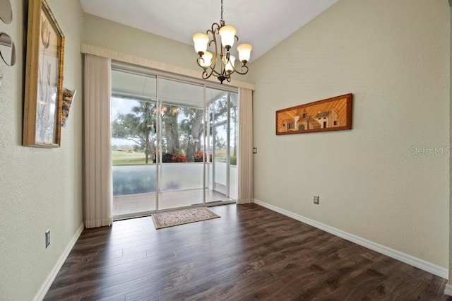 entryway with dark hardwood / wood-style floors, an inviting chandelier, and vaulted ceiling